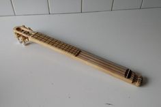 a small wooden instrument sitting on top of a white counter next to a tile wall