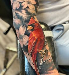 a man with a red bird and flowers on his arm