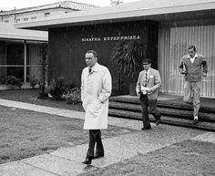 three men in suits and ties are standing outside the santa barbara enterprises office building