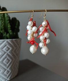 Handmade cluster earrings made with Freshwater Pearls, white color, and Red Coral branches. GOLD PLATED 925 STERLING SILVER Lenght : 5 cm / 1,97 inches * SHIPPING * Your order will be shipped within 1-3 business days from your purchase. You can choose between 2 shipping methods: STANDARD MAIL (NOT TRACEABLE) It is a cheap and fast shipping method, but NOT TRACEABLE. Chapeau Atelier is not responsible for any postal disruptions, delays or losses. REGISTERED MAIL (TRACEABLE) It is an absolutely sa Handmade White Dangle Cluster Earrings, White Pierced Cluster Earrings As Gift, Coral Earrings With Ear Wire As Gift, Handmade Coral Earrings For Gifts, Handmade Coral Earrings For Wedding, Coral Earrings For Gift, River Pearls, Coral Earrings, Natural Coral