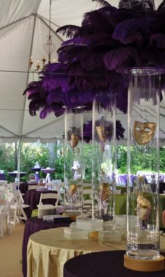 the tables are set up with purple and gold decorations for masqueradee party