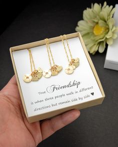 three necklaces in a gift box with a note on the front and two small disc pendants on the back