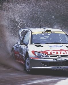 a rally car is driving through the mud