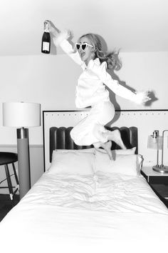 a woman jumping in the air on top of a bed