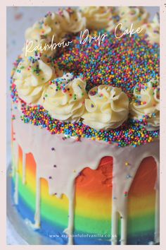 a rainbow drip cake with sprinkles and white frosting on it's side