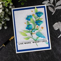 a card with blue flowers on it next to some silverware and a flower arrangement