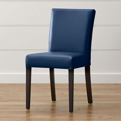 a blue chair sitting on top of a hard wood floor next to a white wall