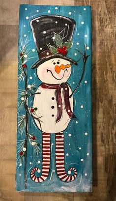 a wooden sign with a snowman painted on it