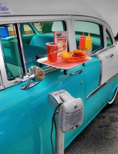 an old car with some drinks on the hood