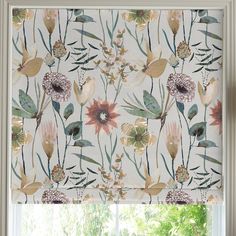 a window with a flowered roman blind in front of it