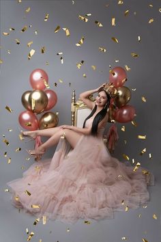 a woman sitting on a chair surrounded by balloons and confetti