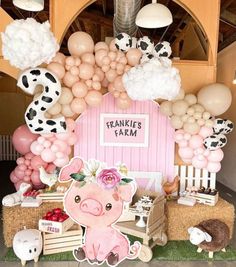 there is a pink barn with balloons and farm animals on the front wall, along with other decorations