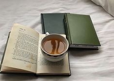 a cup of tea and an open book on a bed