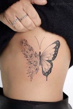 a woman's back with a butterfly tattoo on her lower back, and flowers