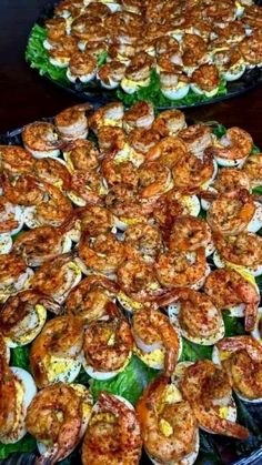 two platters filled with shrimp on top of lettuce and other food items