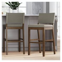 two stools sitting next to each other in front of a counter top with a potted plant on it