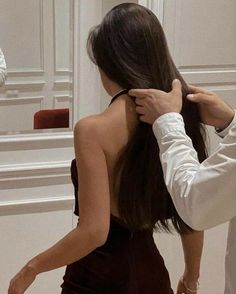 a man adjusting the back of a woman's dress