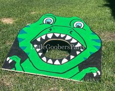 a cardboard cutout of a green alligator with its mouth open