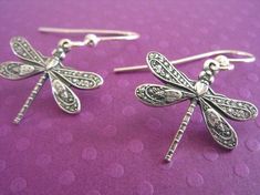 "Detailed antiqued silver charms make an adorable little pair of dragonfly earrings. These small dragonfly earrings come with your choice of ear wires so even sensitive ears will be happy wearing these all day long. ♥ 1 1/8 inches long - may change slightly with your ear wire selection ♥ 1/3 inches wide ♥ Antiqued silver plated dragonflies ♥ Nickel and lead-free ♥ Your choice of ear wires: - stainless steel - stainless steel lever back - silver plated - silver plated lever back - sterling silver Whimsical Silver Hypoallergenic Earrings, Nickel-free Dragonfly Sterling Silver Earrings, Silver Dragonfly Earrings For Gift, Nickel-free Sterling Silver Dragonfly Earrings, Silver Dragonfly Earrings Perfect For Gifts, Hypoallergenic Dragonfly Earrings As A Gift, Hypoallergenic Dragonfly Earrings For Gift, Quirky Girl, Dragonfly Jewelry