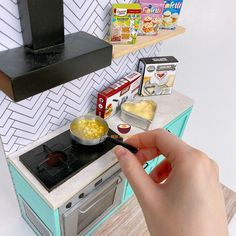 a person is cooking food on the stove in their kitchen, with other items nearby