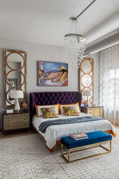 a bedroom with a purple bed and chandelier