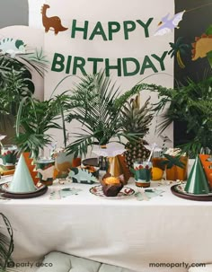 a table topped with lots of plants next to a happy birthday sign