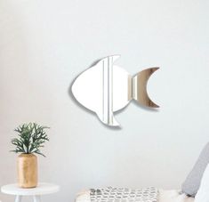 a fish shaped mirror hanging on the wall above a bed