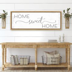 a wooden sign that says gather above a table with two baskets on it and some plants