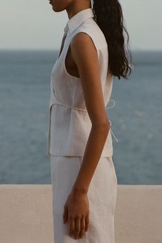 A fitted sleeveless shirt with a wrap front tie closure, cut from 100% European Flax® linen. Cropping at the hips, it features a collared neckline with adjustability from the wrap ties. Pair with a relaxed trouser or the Antibes Short for elevated casual wear. Peony Swimwear, White Sleeveless Shirt, Elevated Casual, Coastal Granddaughter, Maxi Dress Sale, Wrap Shirt, Swim Shirts, Skin Care Gifts, Faithfull The Brand