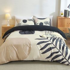 a bed with black and white comforters in a bedroom next to a night stand