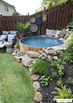 an above ground pool surrounded by rocks and plants