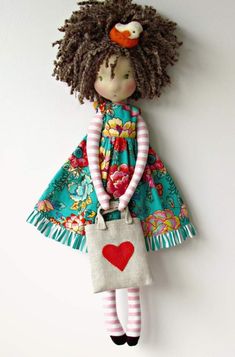 a doll hanging on the wall with a purse in it's hand and wearing a dress