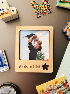 a photo frame with the words world's best dad on it surrounded by magnets