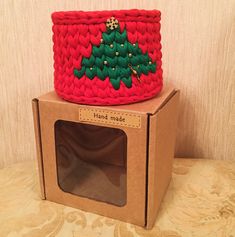 a handmade christmas basket sitting on top of a cardboard box with the lid open