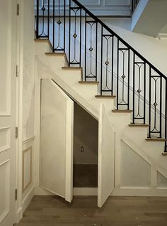 an open door is in the middle of a staircase leading up to a second floor