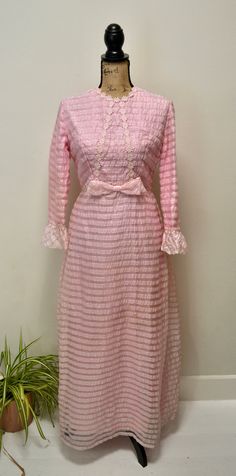 "-Showstopping 70s pink maxi dress-  (please note this dress has some light staining on front and is reflected in price- see photos.  This is not overly noticable and may come out.) -Features- -Pretty pink -2 layers - polyester lining and more delicate polyester striped pink/sheer outer layer -Ruffled sleeve cuffs -Floral applique detailing -Bow front -Metal back zipper and clasp -Measurements- Bust: 34\" Waist: 26\" Hips: 36\" Length: 54\" Sleeves: outer 21\" inner 15\" Shoulders: 15\" Thanks f Pink Long Sleeve Vintage Dress For Summer, Vintage Long Dresses For Spring, Vintage Pink Long Sleeve Midi Dress, Feminine Vintage Maxi Dress, Spring Vintage Floor-length Dress With Ruffles, Long Pink Feminine Dress, Vintage Pink Midi Dress For Party, Vintage Pink Dress For Garden Party, Pink Retro Midi Dress