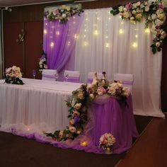 the table is decorated with flowers and candles for an elegant wedding reception in purple tones