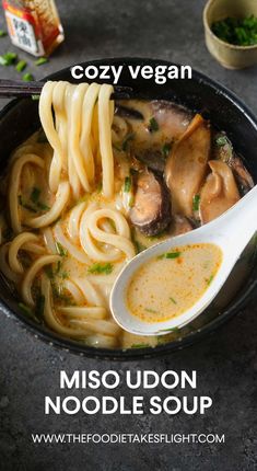 a bowl of miso udon noodle soup is shown with a spoon in it