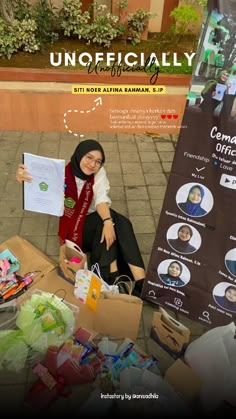 a woman sitting on the ground with some boxes and papers in front of her,