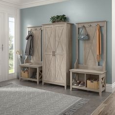 a room with blue walls and two large wooden storage cabinets next to a rug on the floor