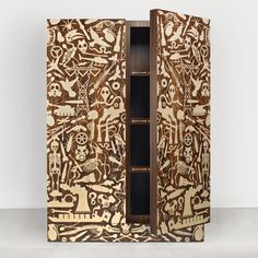 an intricately carved wooden cabinet with open doors and decorative designs on the door, in front of a white wall