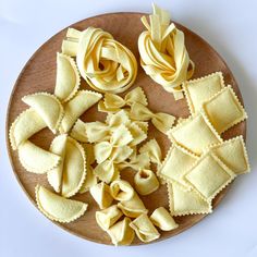 several types of pasta on a wooden plate