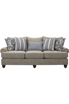 a gray couch with blue and white pillows on top of it's back end