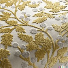 an embroidered fabric with gold and white flowers on it