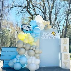 a baby shower sign and balloons are on the ground in front of a blue box