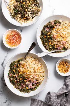 three bowls filled with different types of food on top of a white countertop next to silver spoons