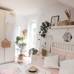 a bed room with a neatly made bed and lots of plants