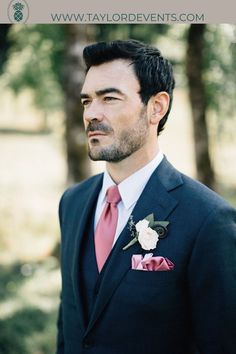 a man in a suit and pink tie