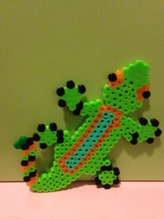 a green and orange lizard made out of perler beads