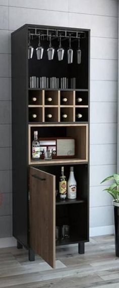 an open bookcase with drinks on it in front of a potted plant and window